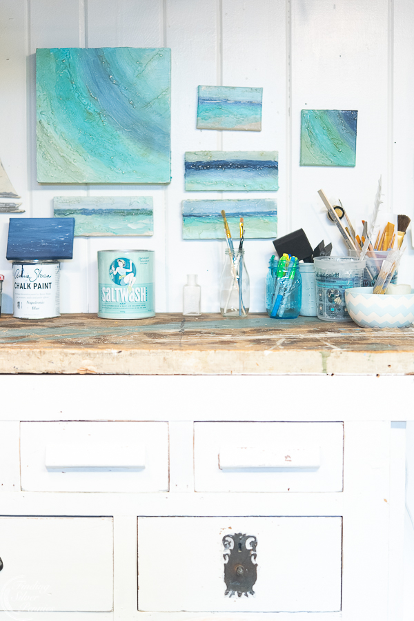 Studio with work bench, white walls, and abstract paintings