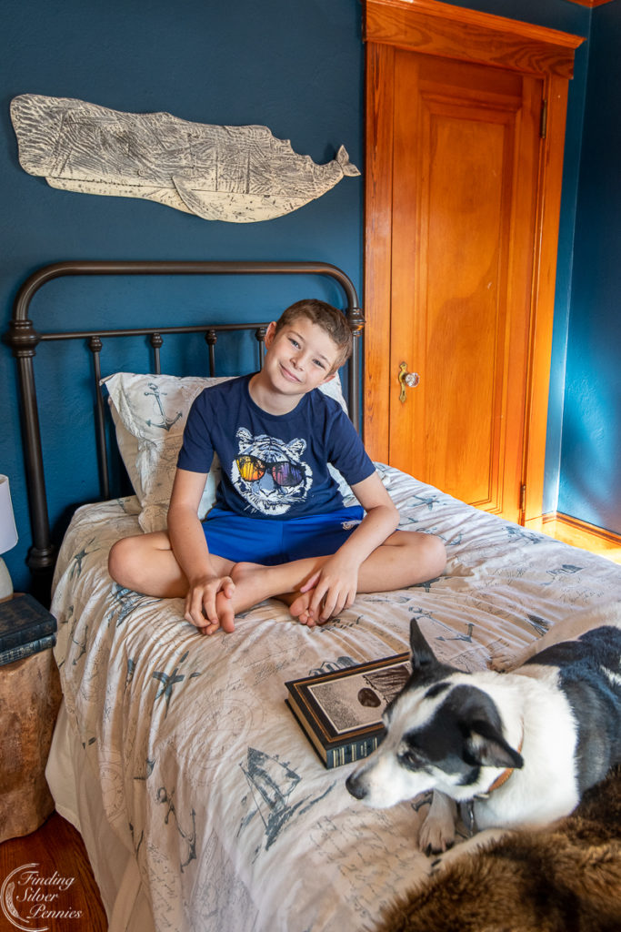 Boy and his dog sitting on a bed